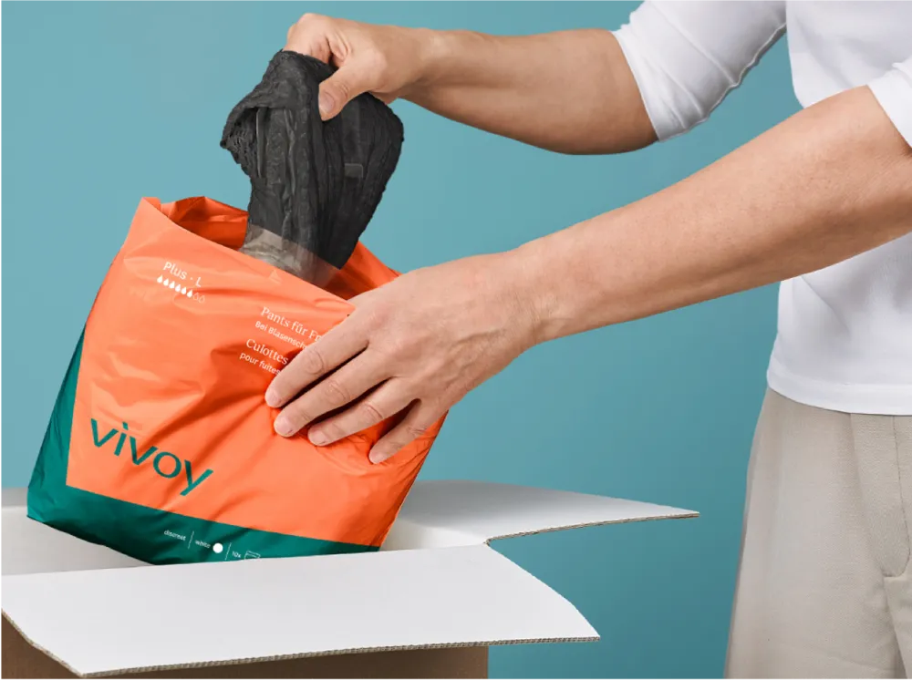 Subtle pants from vivoy Someone unwraps a pair of black pants from a vovoy package.